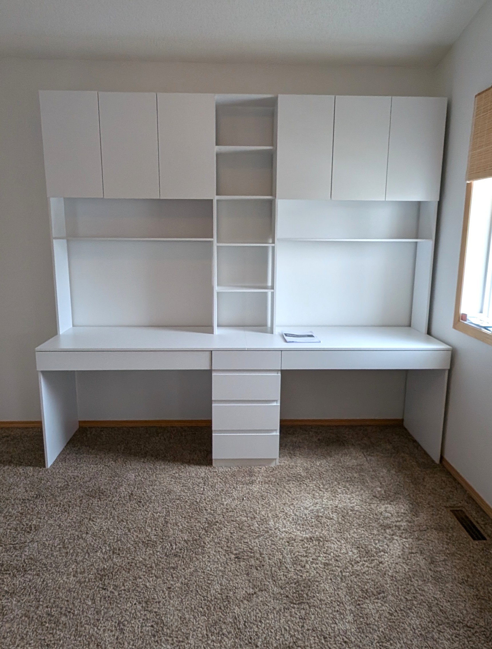 Office workstation assembled with mounted cabinets and shelves in Calgary SE.
